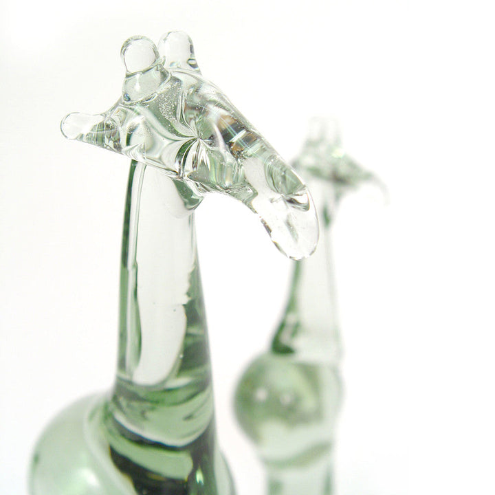 Recycled glass giraffe figurine close-up, clear-green body with raised head and legs