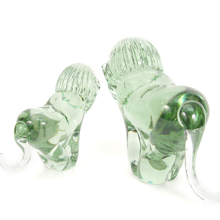 Clear recycled-glass lion figurine, front-and-side view, curled tail visible.