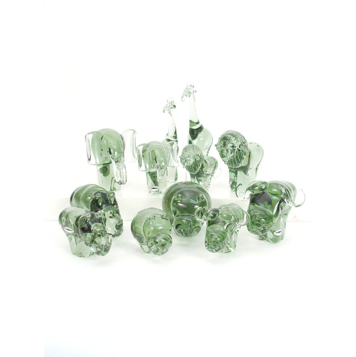 Group of small recycled glass animal figurines in translucent green, assorted shapes.