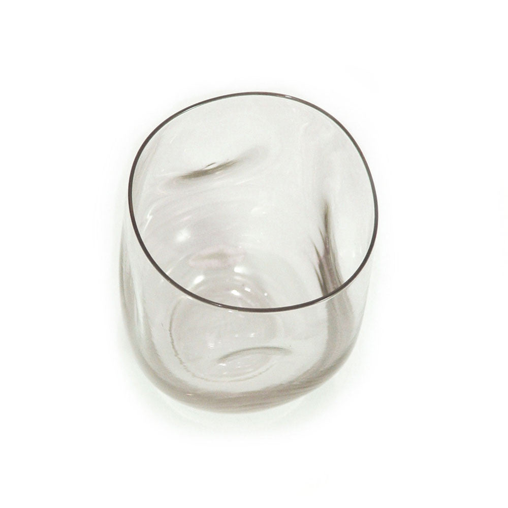 Dented clear water glass viewed from above, wide open rim