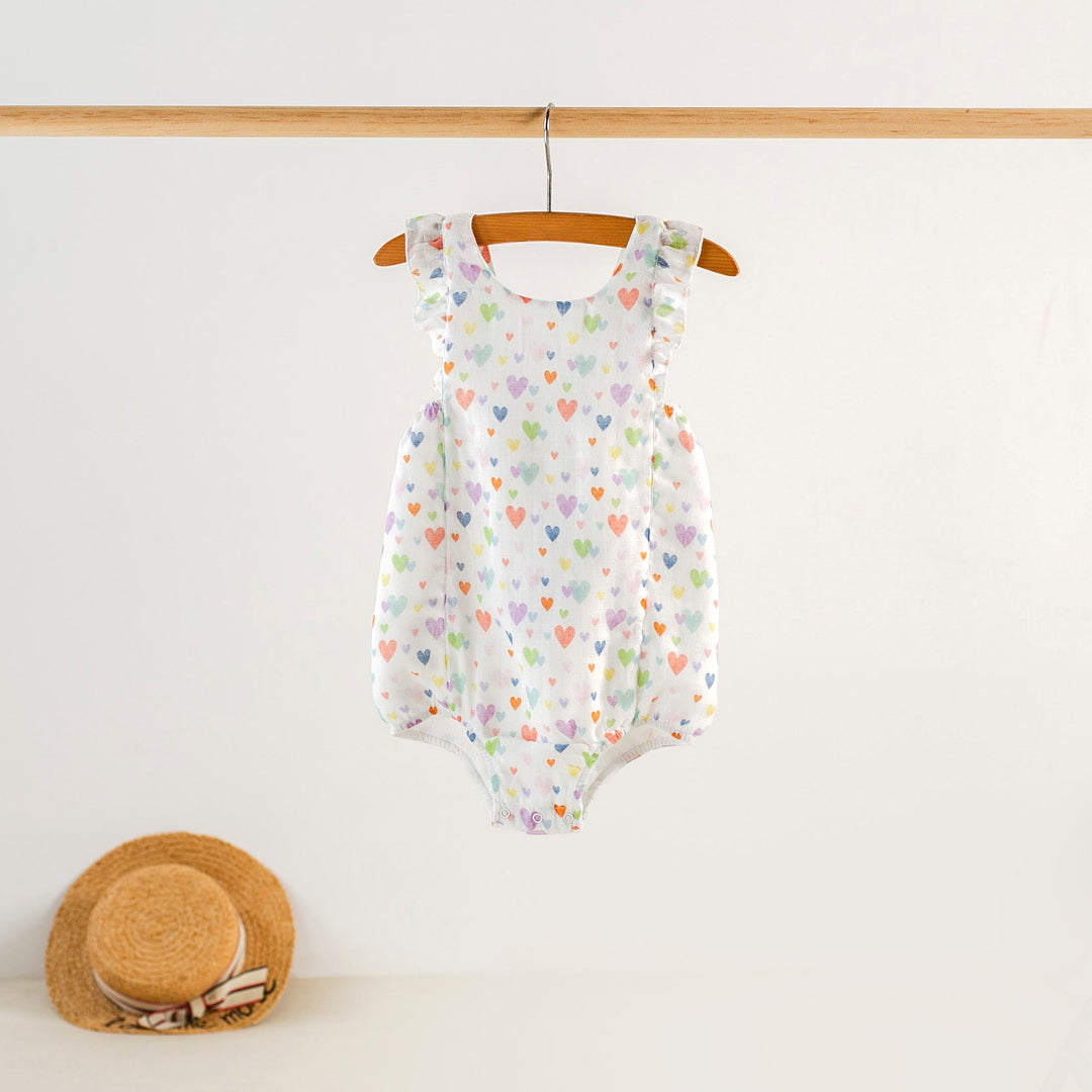 White heart-print organic muslin bubble romper with ruffle shoulder straps and snap legs