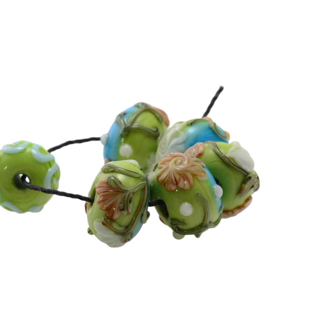 Lampwork glass beads set on black cord, mixed green and blue floral beads