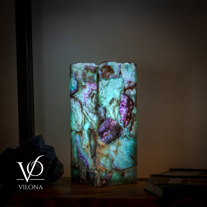 Fluorite table lamp in square stone block, teal, violet, and dark mineral accents.