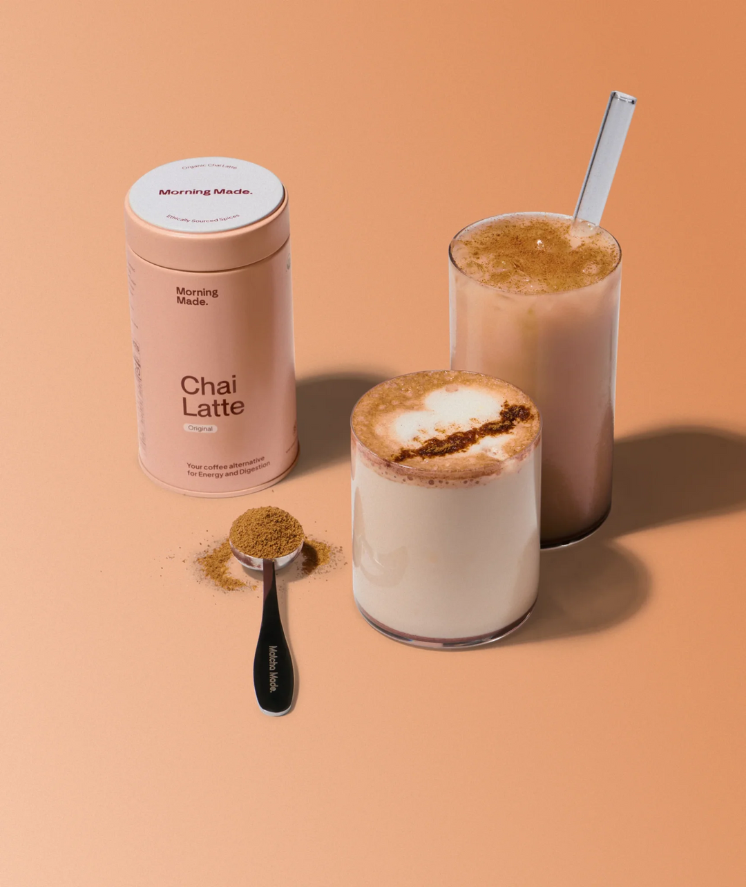 Chai latte canister beside two iced drinks with straws and foam