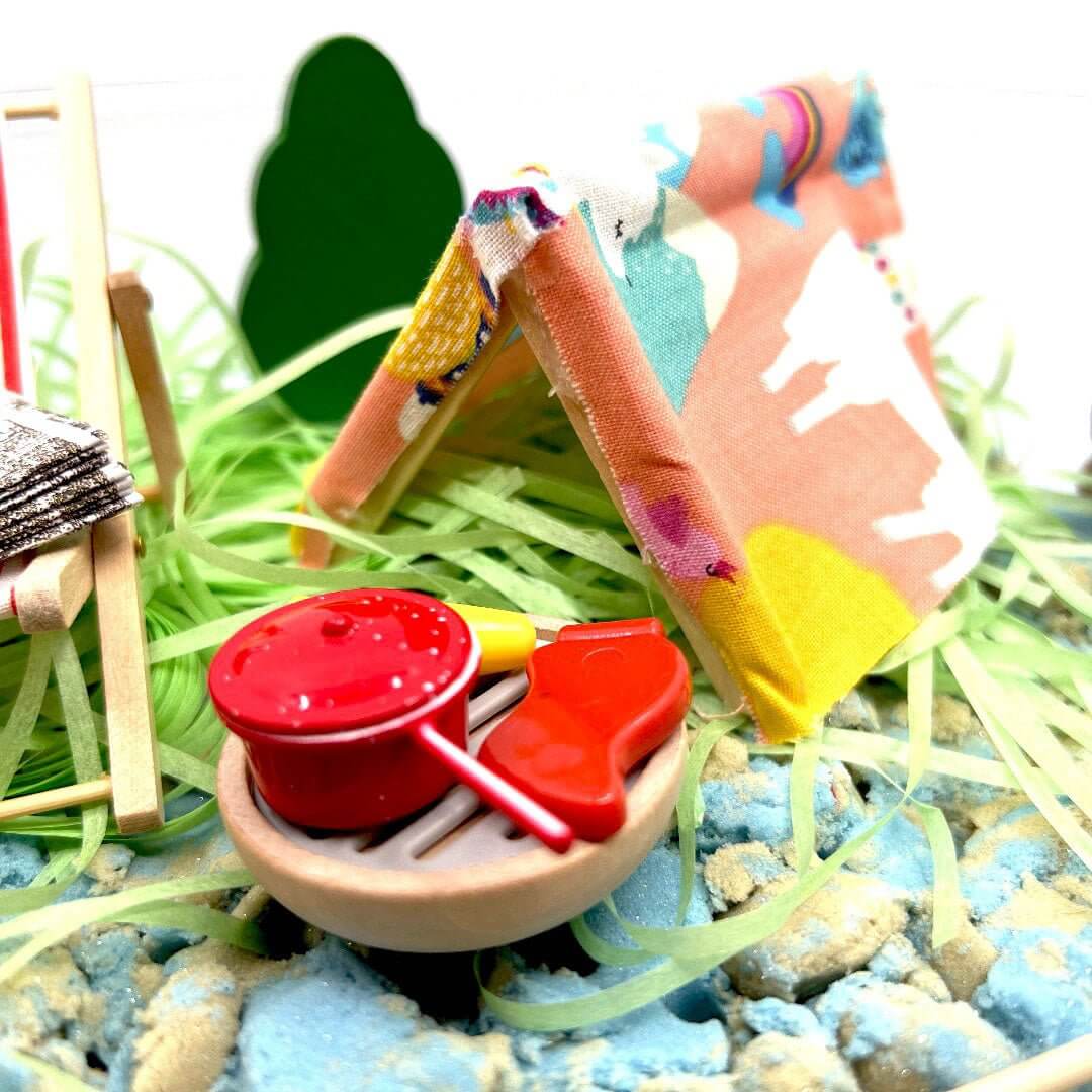 Kinetic sand play tray with red pans, tools, and small animal figures