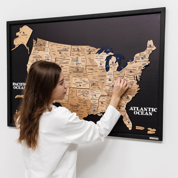3D wooden USA map wall art with hand pointing at states on black board