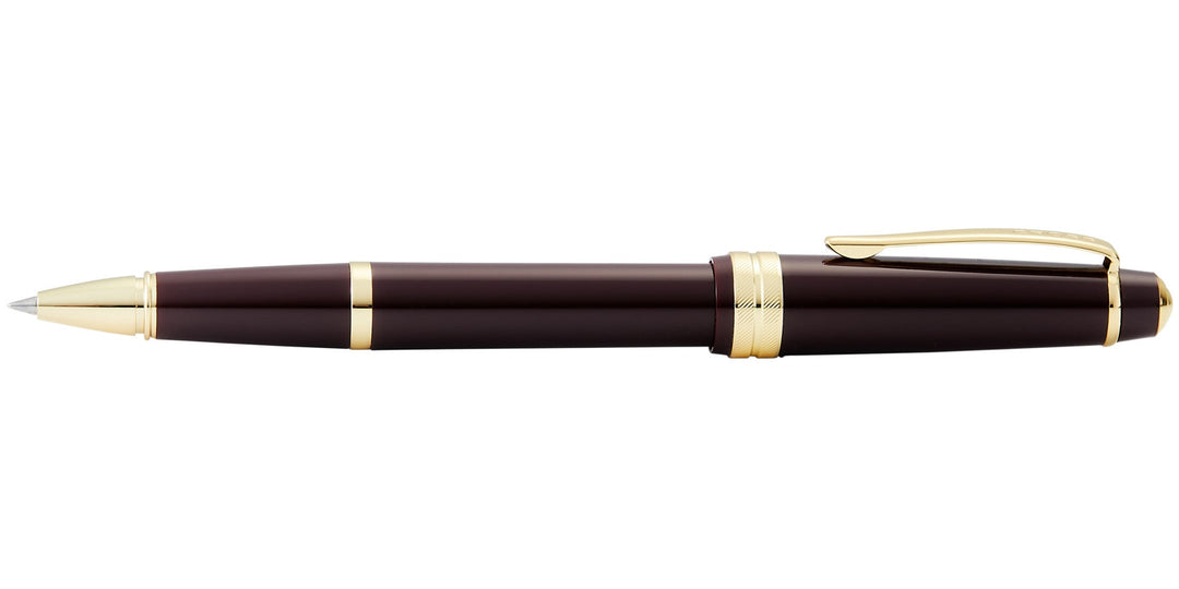 Burgundy resin rollerball pen with gold-tone trims and pointed tip, side view