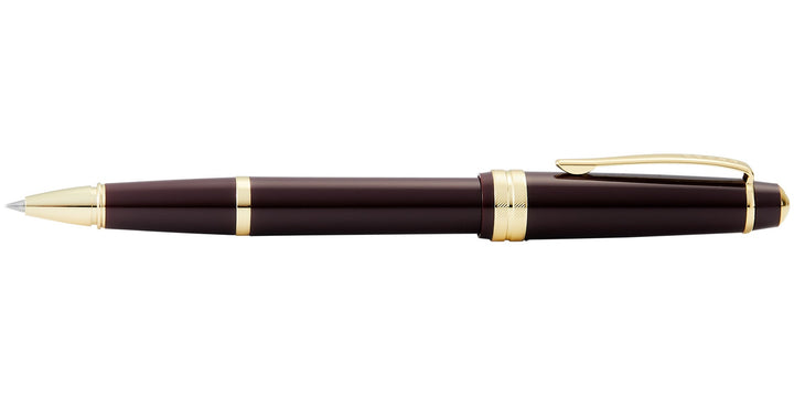 Burgundy resin rollerball pen with gold-tone trims and pointed tip, side view