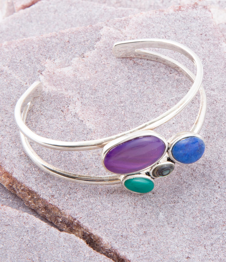 Sterling silver cuff bracelet with purple oval center and blue/green side stones