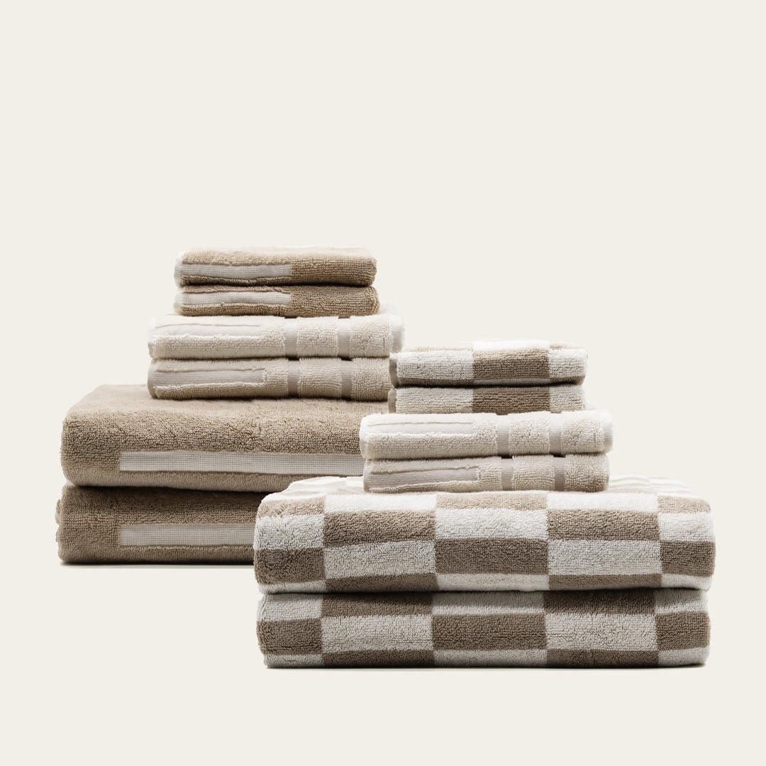 Stack of beige and white checkered cotton towels, folded with multiple sizes