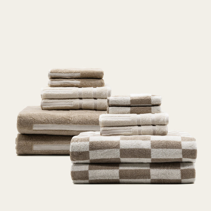 Stack of beige and white checkered cotton towels, folded with multiple sizes