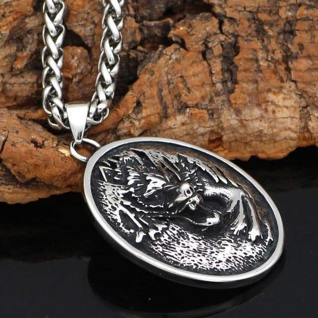 Stainless steel oval wolf pendant with chain, side view of engraved wolf design.