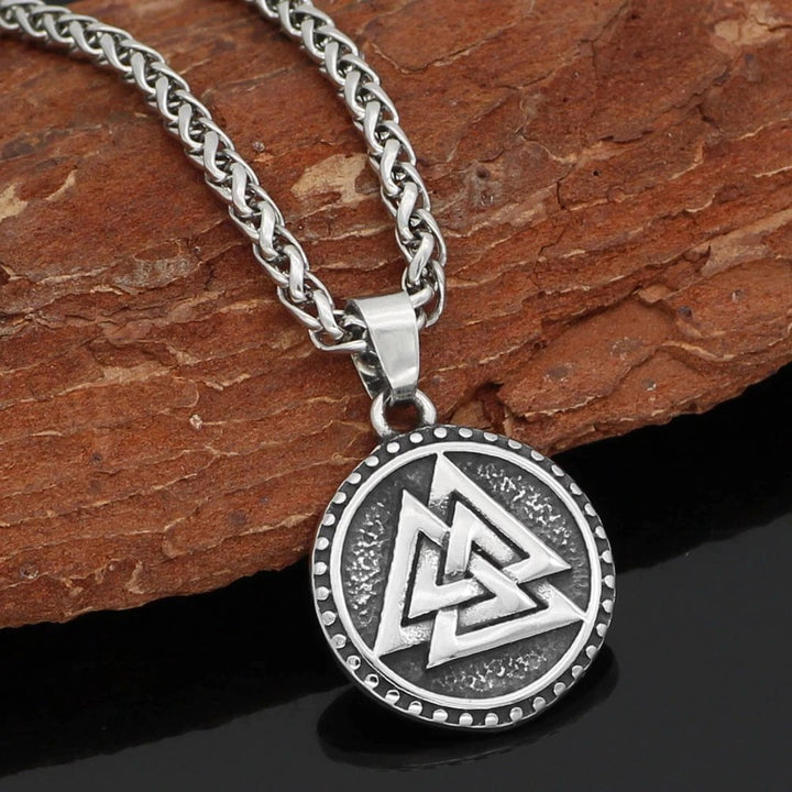Stainless steel necklace pendant with Valknut symbol in a round textured frame.