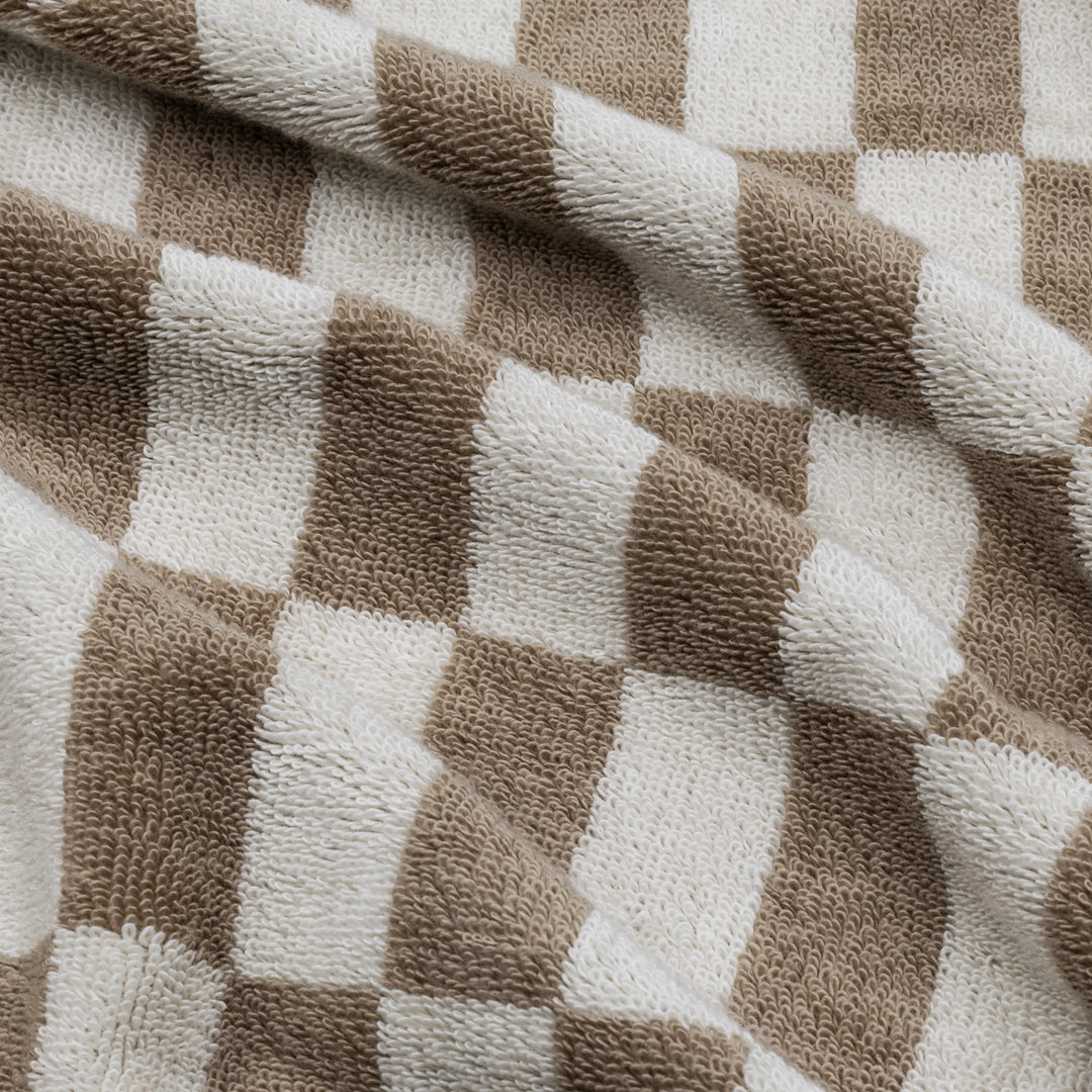 Close-up of tan and ecru checkered cotton towel with textured loops