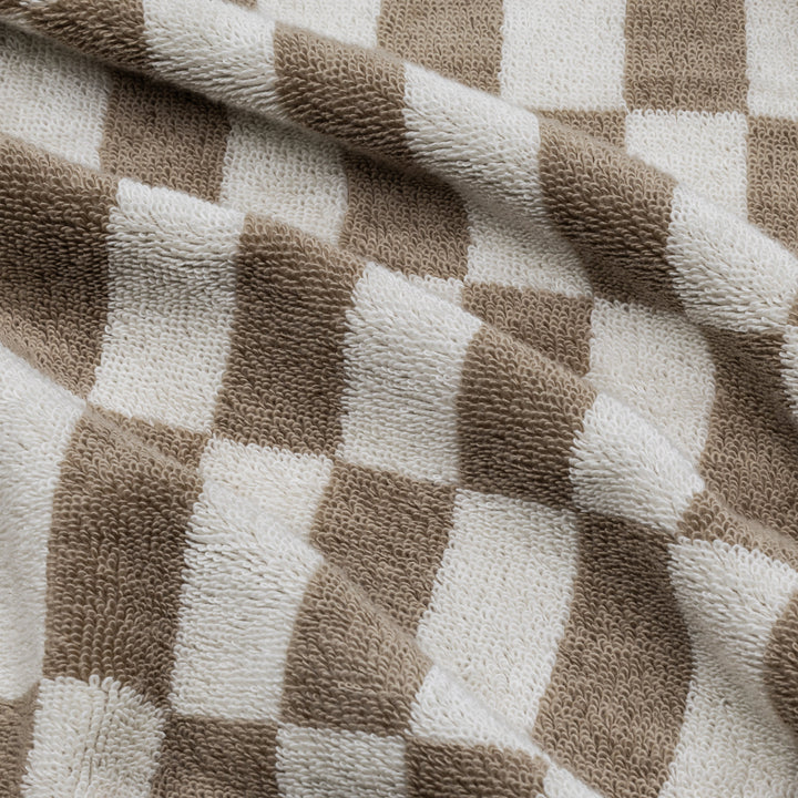 Close-up of beige and white checkered cotton towel fabric with textured weave