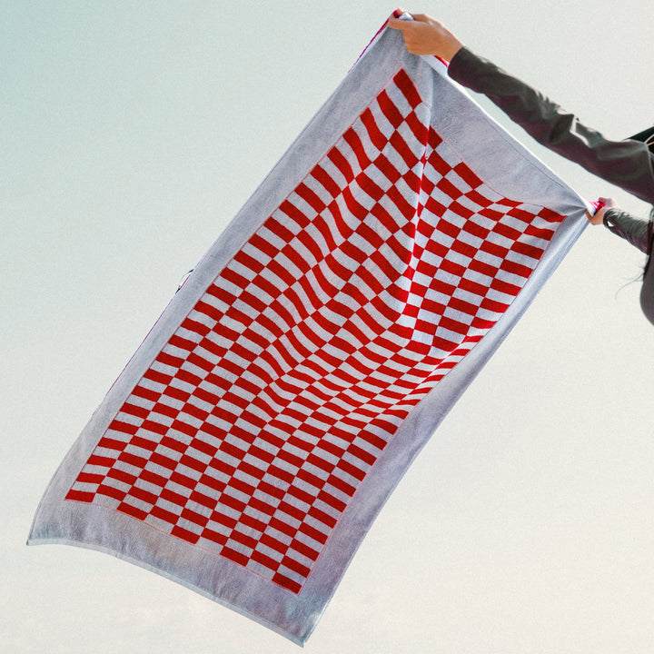 Red and white checkered cotton towel laid flat, full pattern and hem shown.