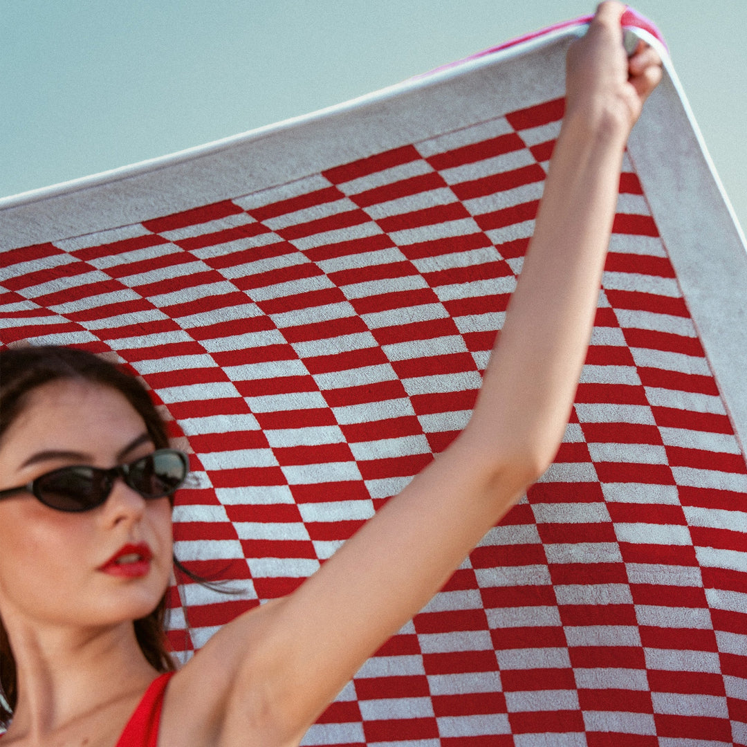 Large red and white checkered cotton towel stretched out, hem edge visible.