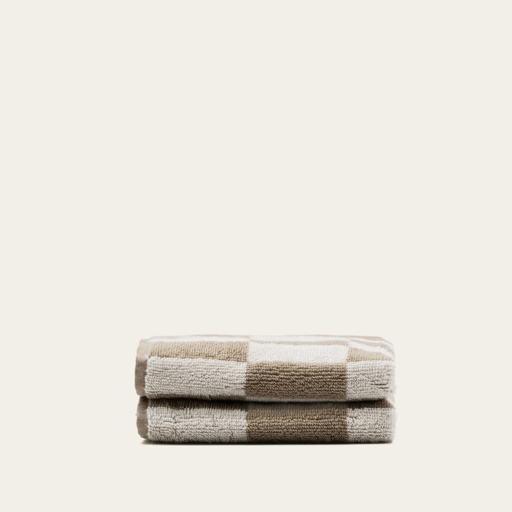 Compact stack of tan and ecru checkered cotton towels, neatly folded