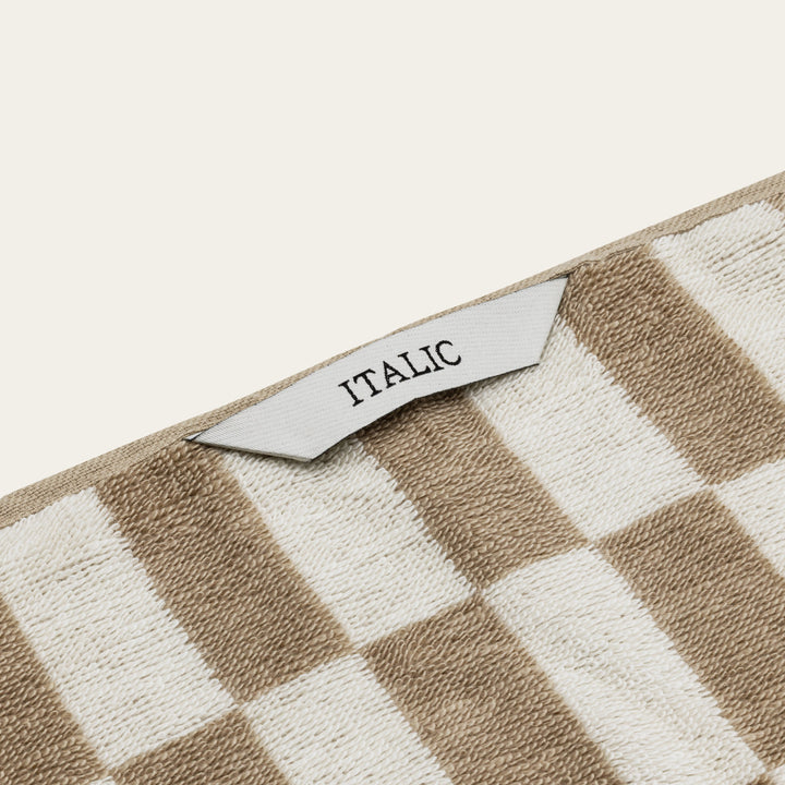 Checkered cotton towel corner with small fabric label reading “ITALIC”