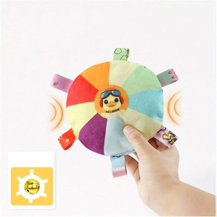 Hand-held plush flying disc chew toy with multicolor wheel, fabric tags, and smiling face
