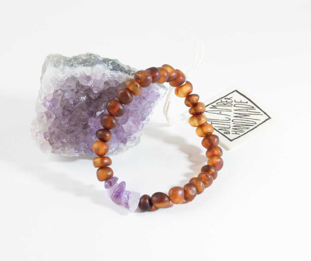 Amber-brown bead bracelet with raw purple amethyst and a hanging tag
