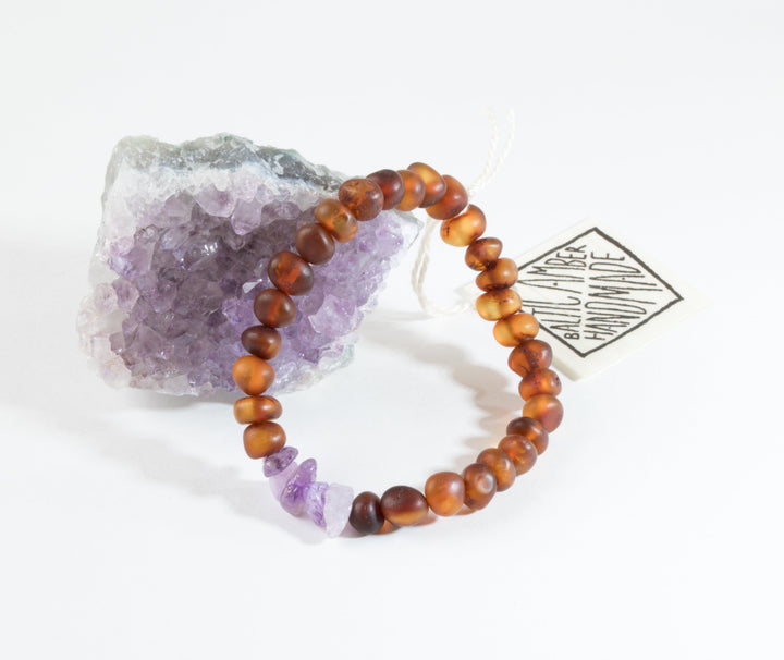 Amber-brown bead bracelet with raw purple amethyst and a hanging tag