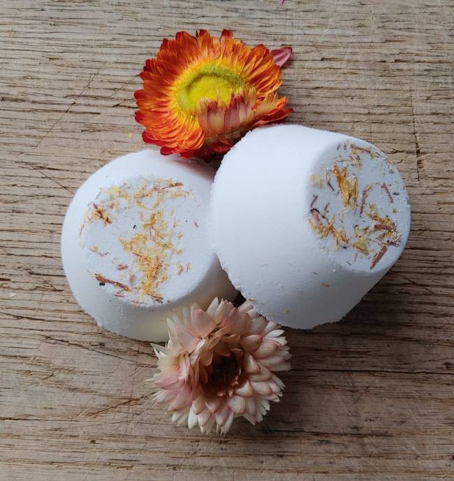 Pair of white shower steamers with dried botanicals and orange-yellow flower