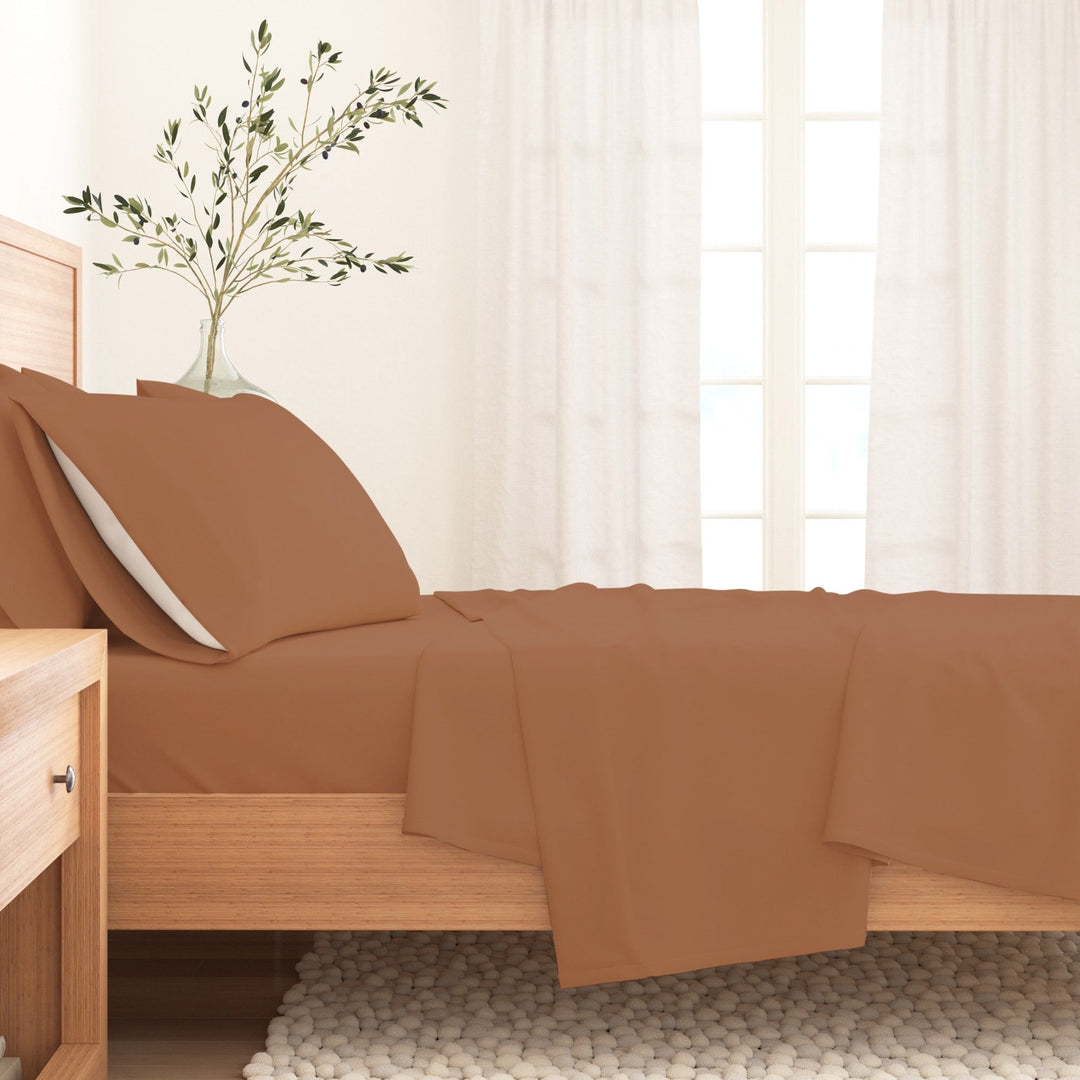Solid cotton flannel sheet set in camel brown on a bed with pillow and sheet drape