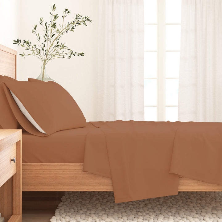 Solid cotton flannel sheet set in camel brown on a bed with pillow and sheet drape