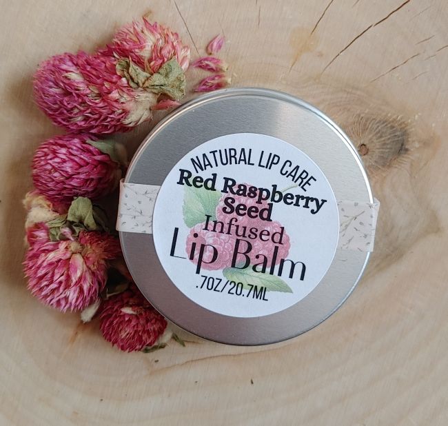 Red raspberry seed infused lip balm tin with Natural Lip Care label