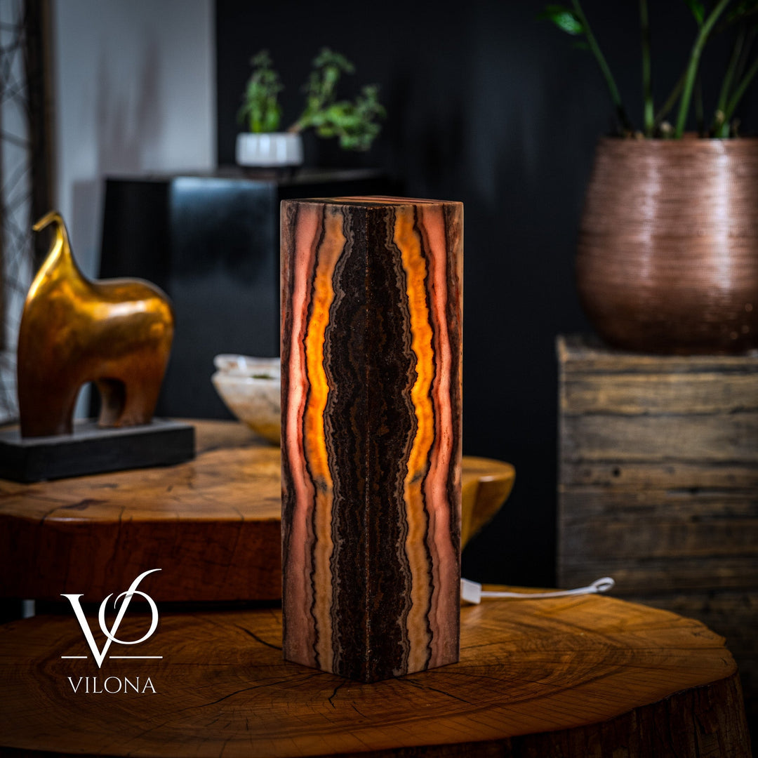 Table lamp with rectangular onyx-style body, dark center with amber-orange vertical bands