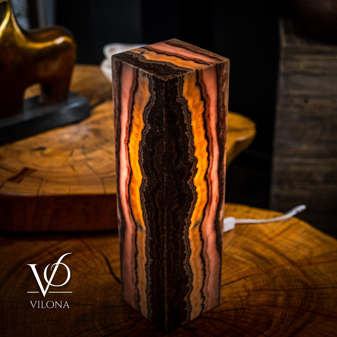 Table lamp with rectangular onyx-style column, glowing amber-orange bands around dark core
