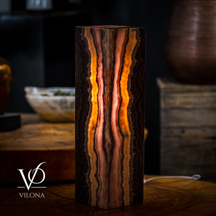 Table lamp with onyx-style rectangular base, warm orange and pinkish streaks over dark bands
