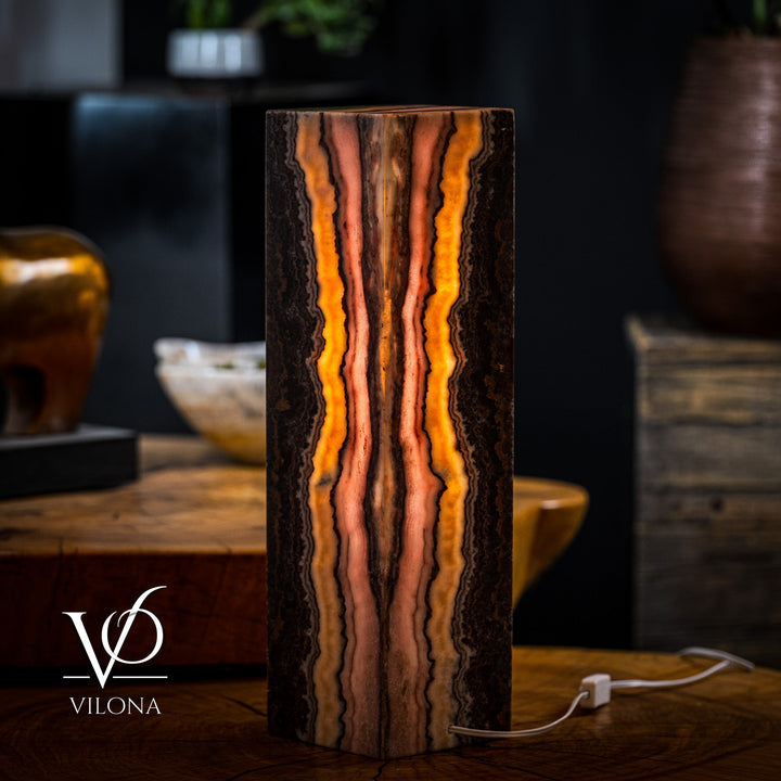 Rectangular onyx-style table lamp with tall vertical orange lines and dark center, white cord