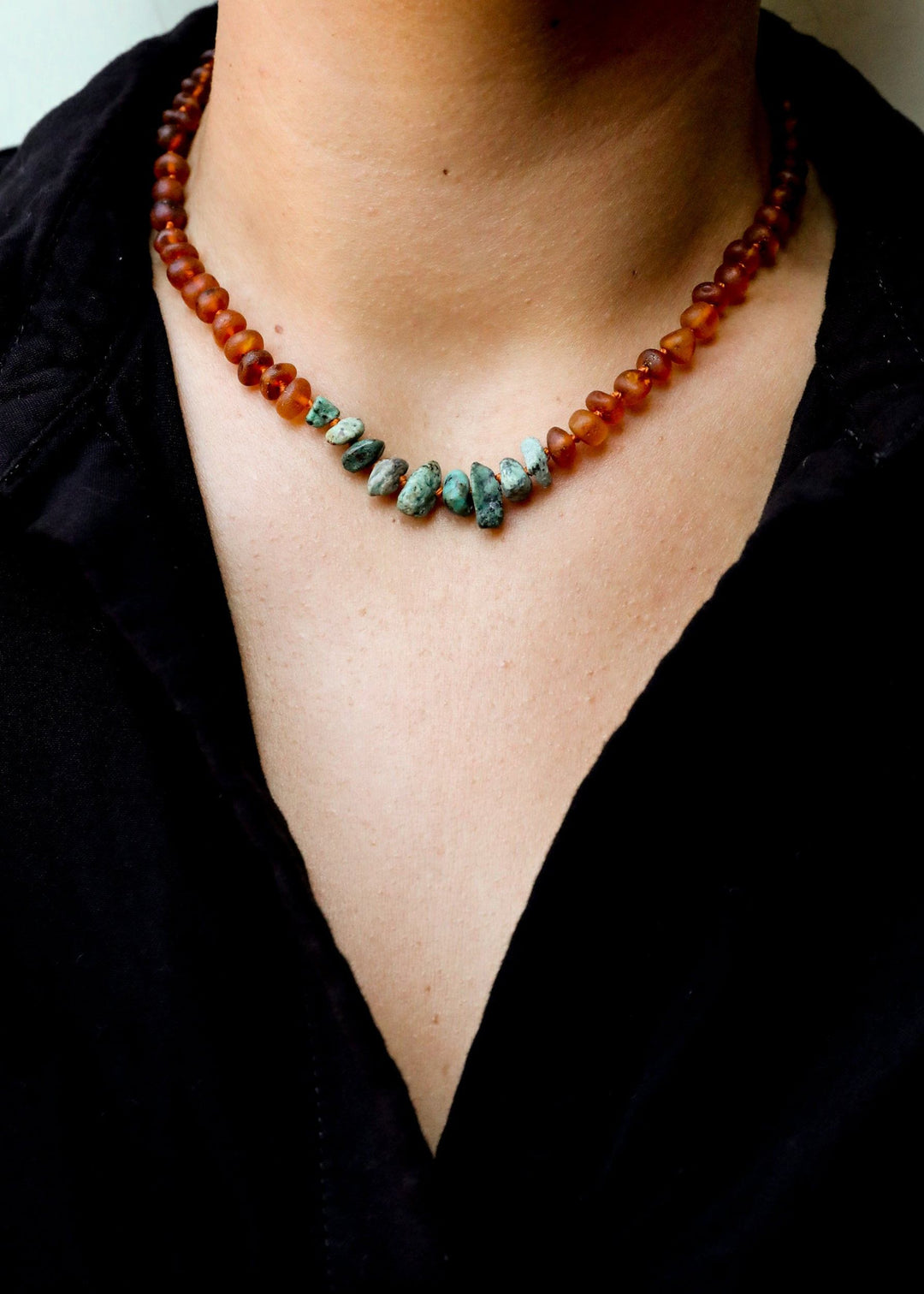 Amber and turquoise jasper bead necklace worn on neck with black shirt