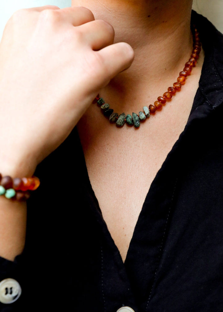 Close-up amber and turquoise jasper bead necklace on collarbone