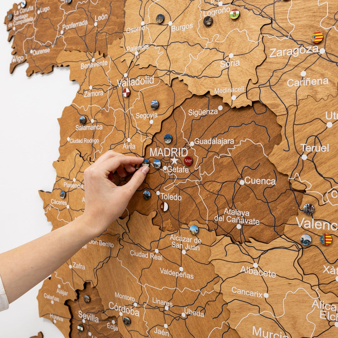 Oak wooden map of Spain with engraved roads and Madrid area, showing a pin placement