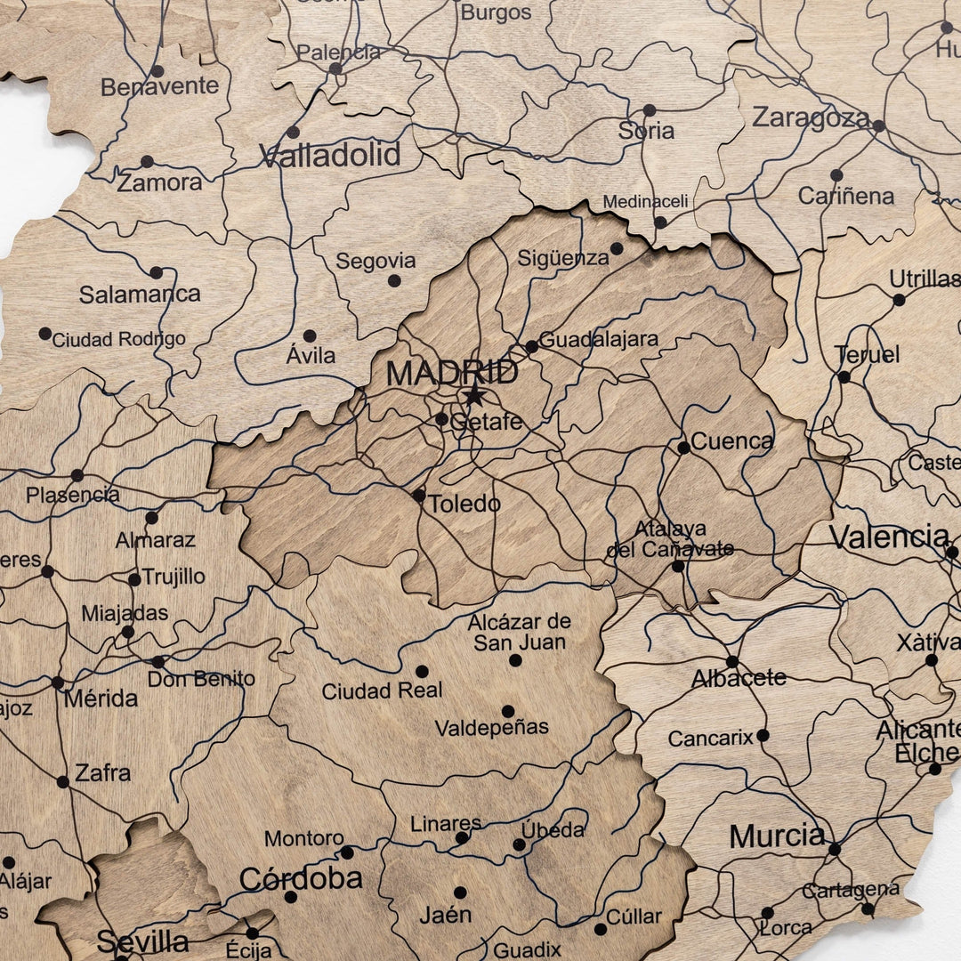 Wooden Spain map close-up with carved borders, town names, and thin road lines