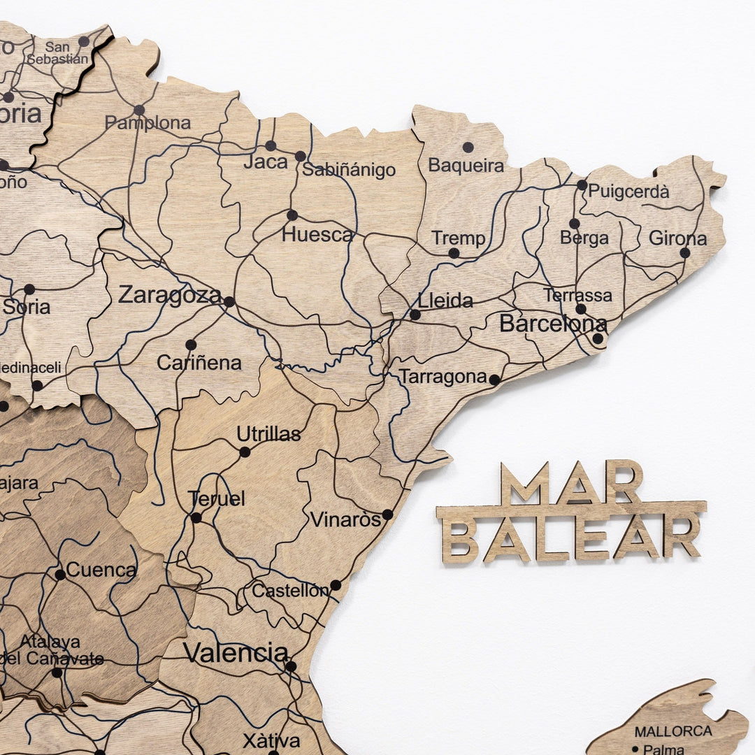 Wooden Spain map with carved coastal names, region outlines, and colored push pins