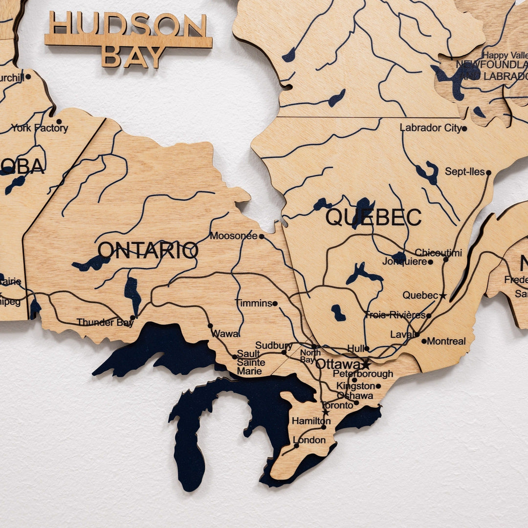 Detail view of wooden 3D Canada map with Quebec and Ontario labels and blue waterways