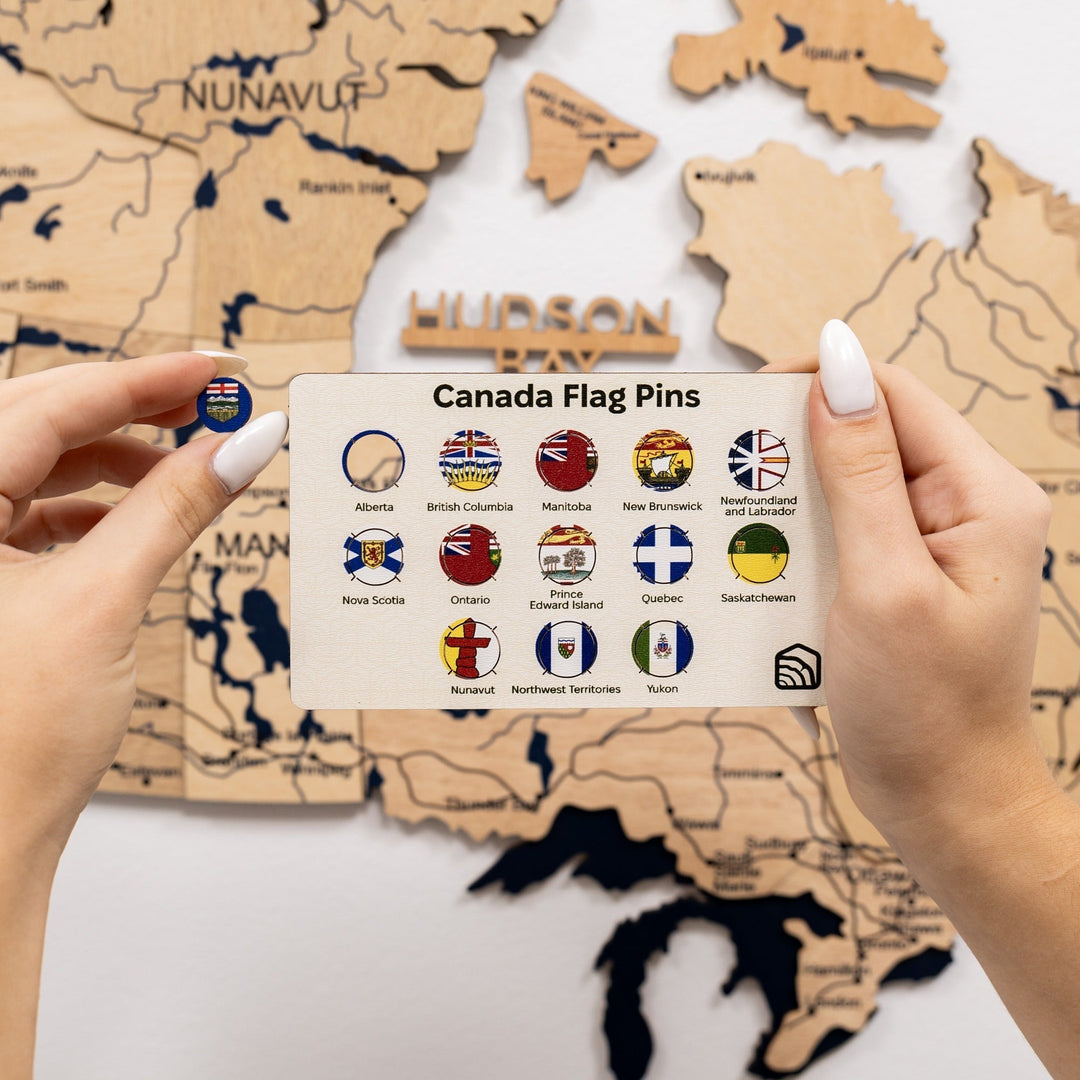 Gold 3D Canada wooden map with embedded flag pins and legend card in hand