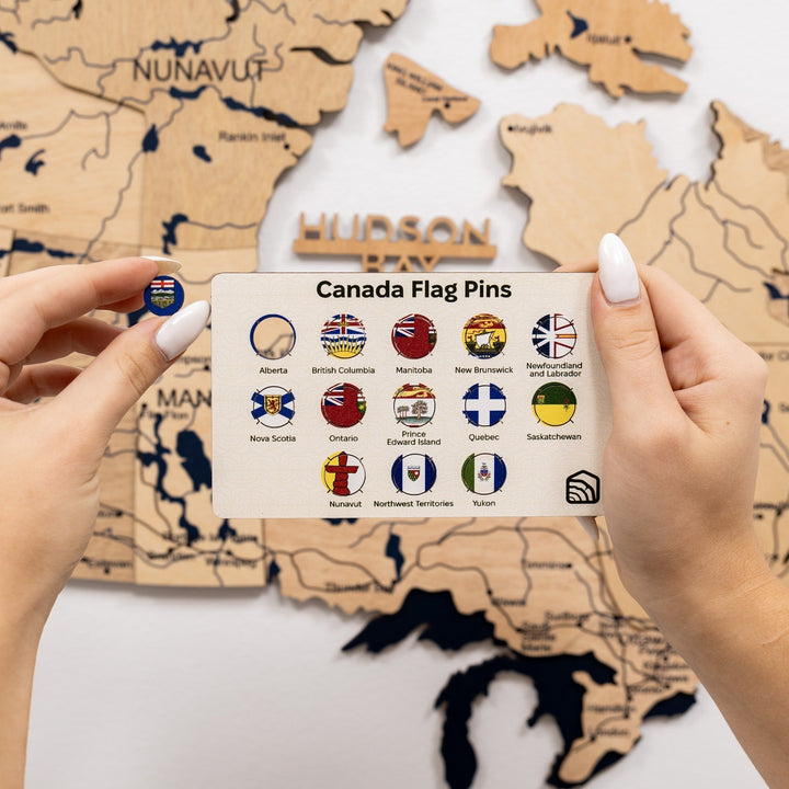 Gold 3D Canada wooden map with embedded flag pins and legend card in hand