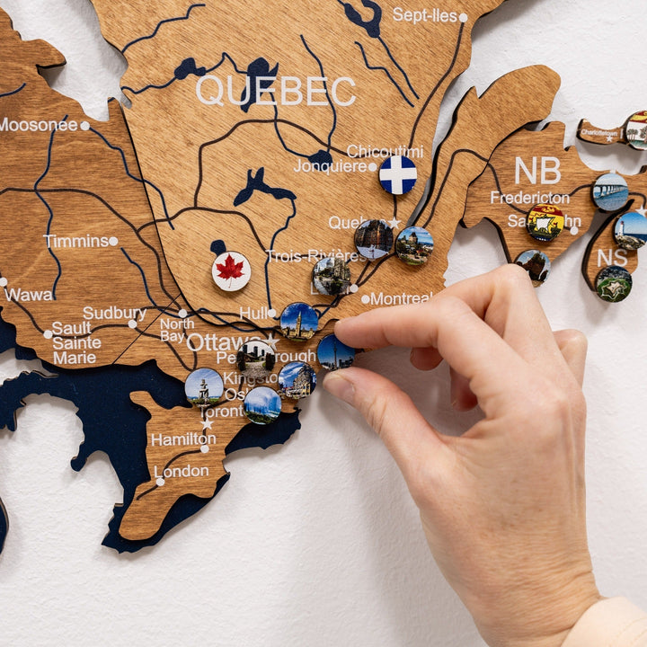 Wooden Canada map close-up with round pins and province names around Ottawa