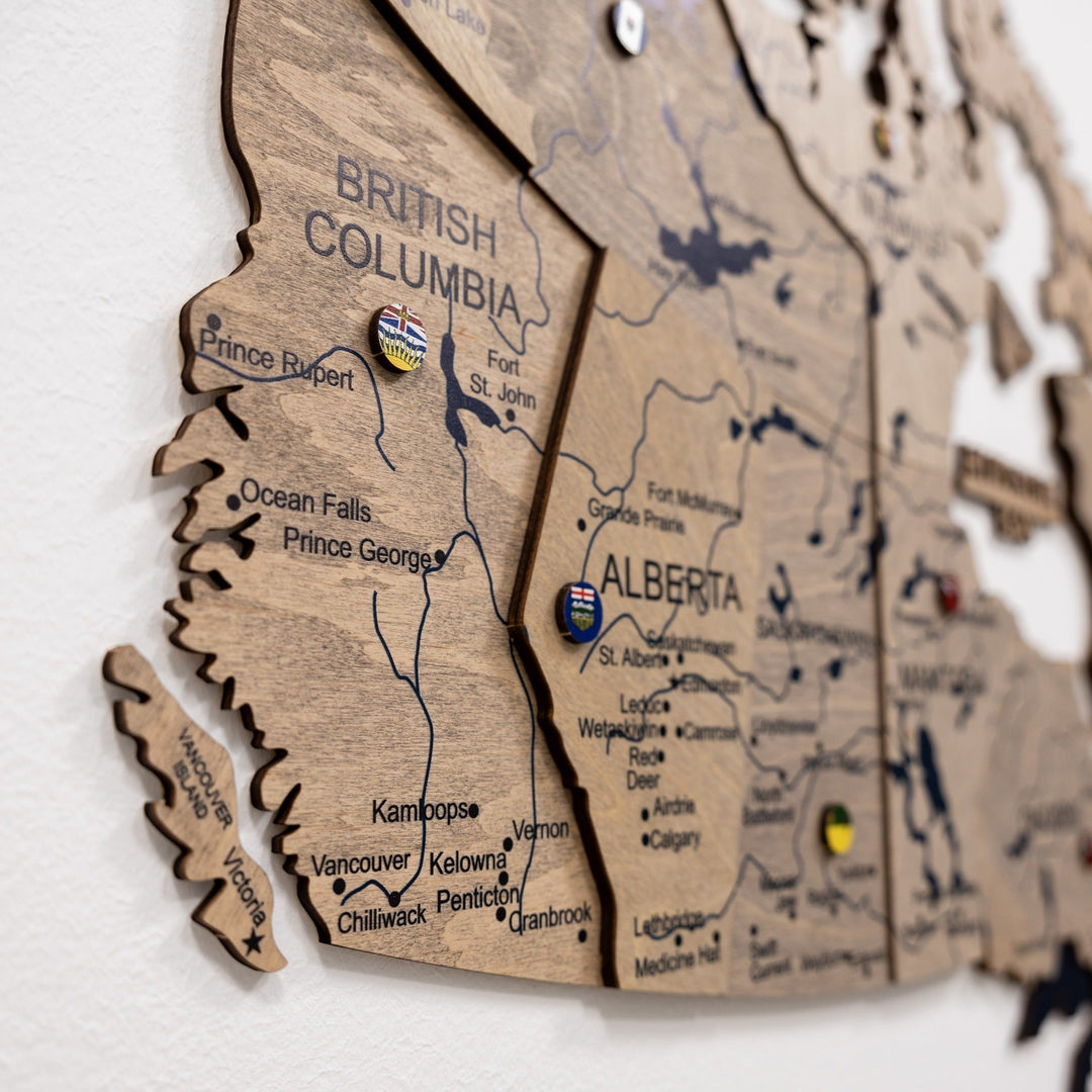 Wooden Canada map close-up with raised regions and printed boundaries across British Columbia.