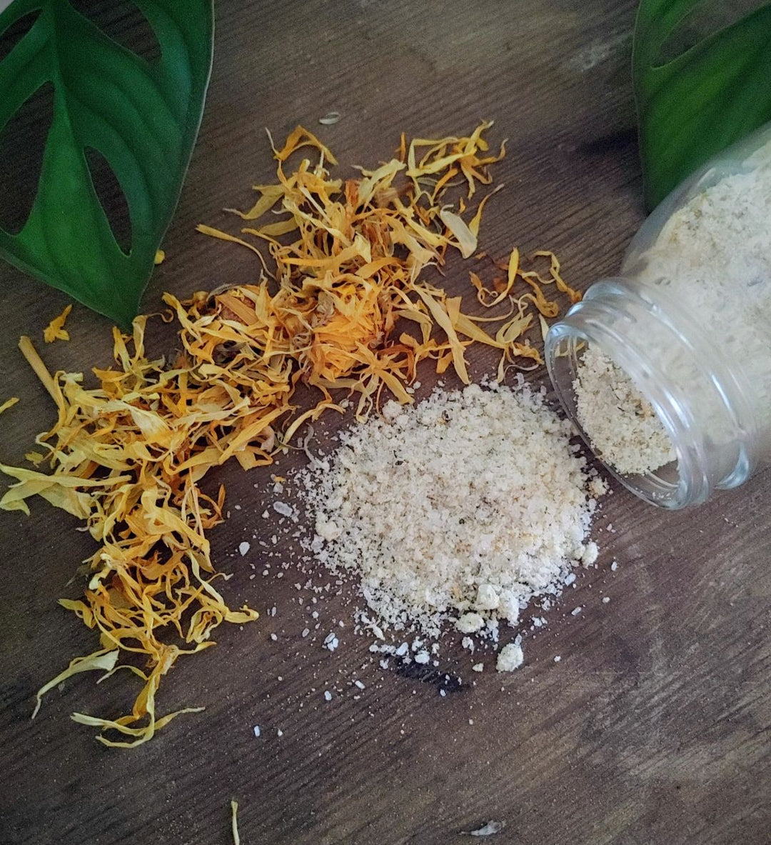 Bath soak blend with white salts and dried yellow botanicals, with small glass jar