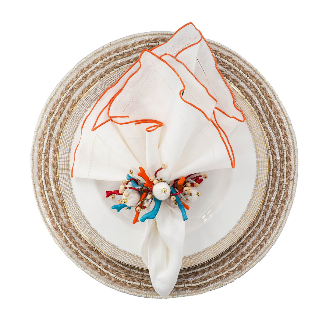 Set of 4 white linen napkins with orange ruffled hemstitch edges, round folded display