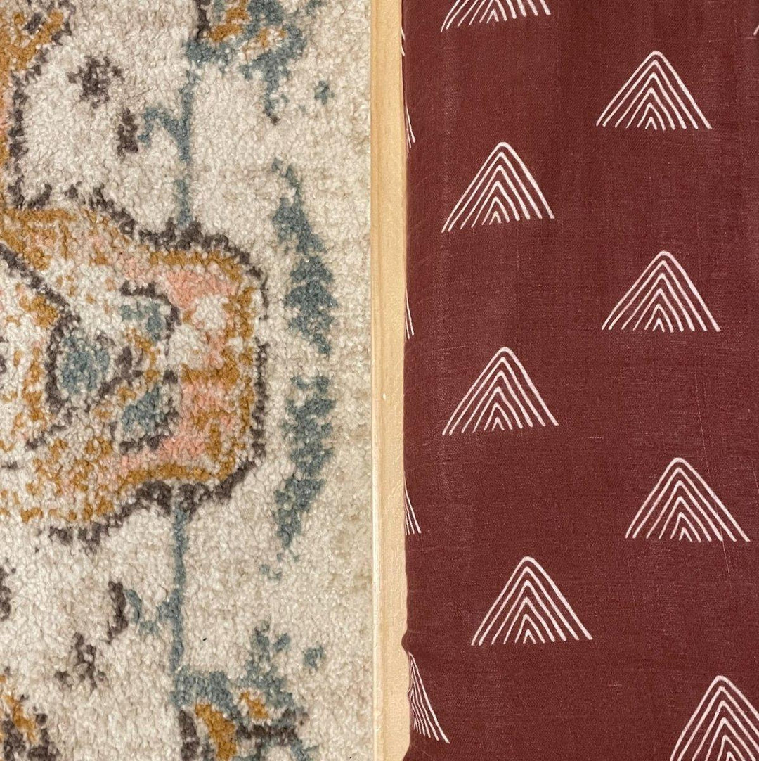 Burgundy fitted crib sheet with white tribal triangle line pattern, close-up fabric