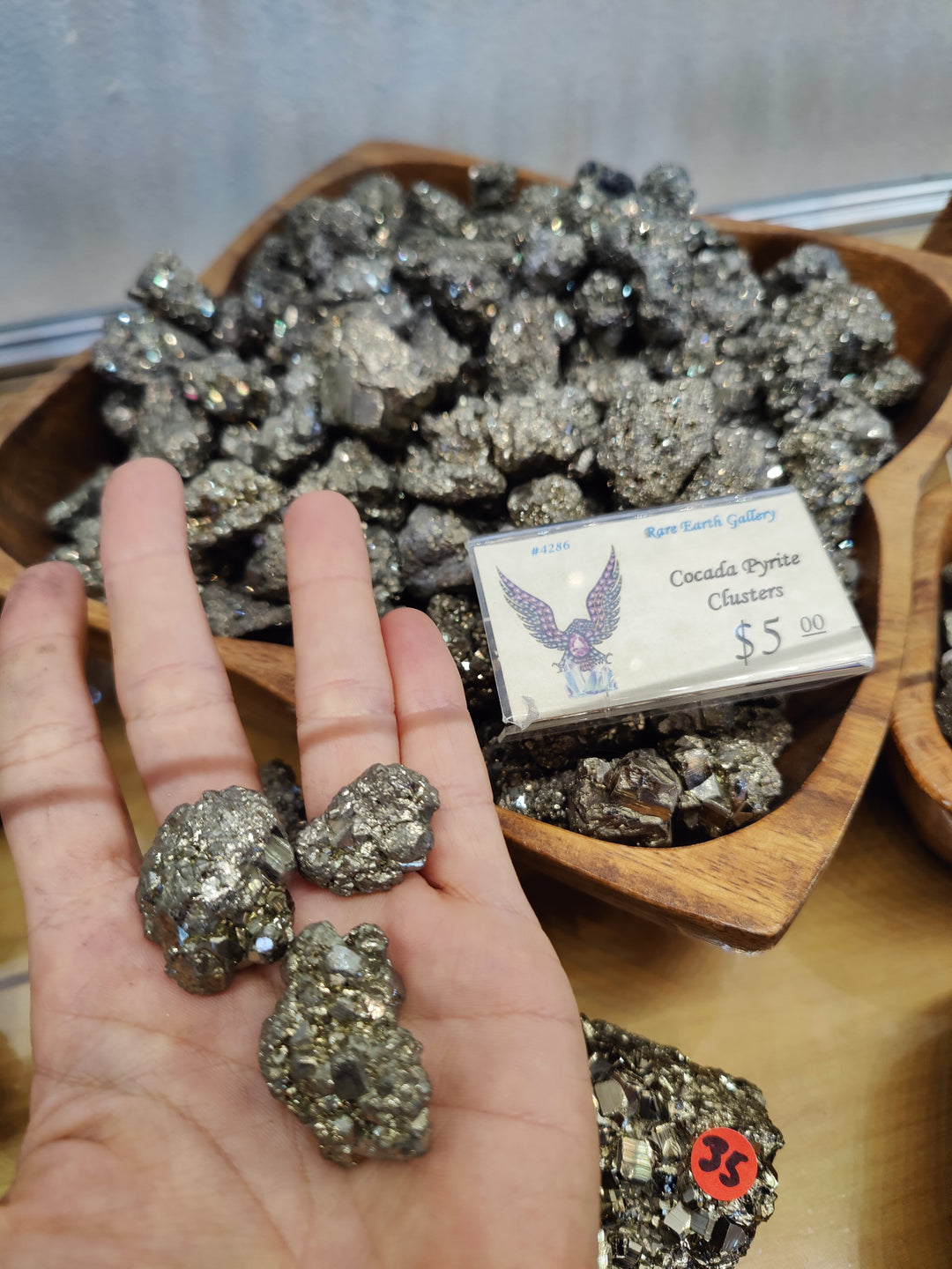Pyrite crystal cluster set, metallic gray sparkly stones shown with a hand for size