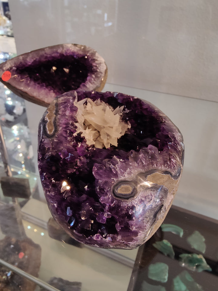 Amethyst geode sculpture showing deep purple druzy cavity and cream calcite crystals
