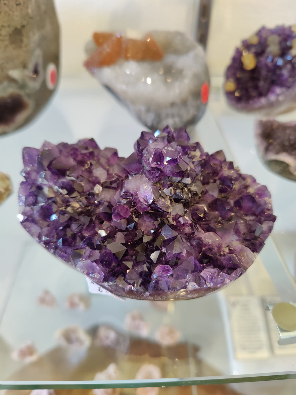 Purple amethyst crystal geode cluster in a heart-shaped display dish